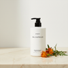 Byredo Bal D'Afrique Conditioner 450ml lifestyle flat lay on cream marble with marigold flowers