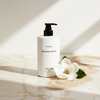Byredo Mojave Ghost Body Lotion 450ml lifestyle on cream marble with magnolia